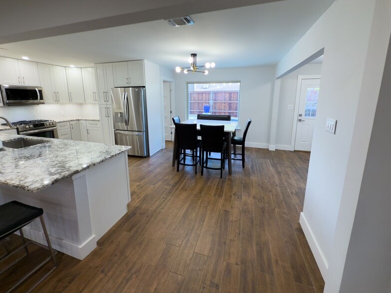 Kitchen and dining area with modern light fixture and stainless appliances - 2006 Candle Ct