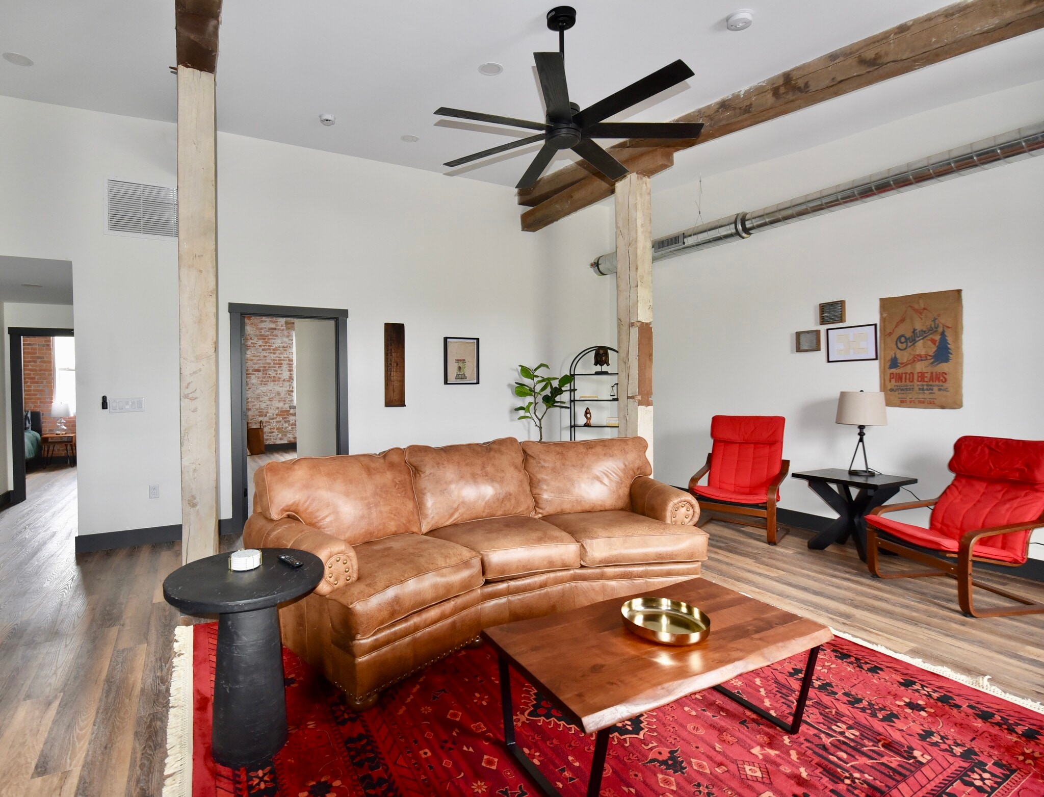 The living room area features ample seating space, a smart TV, a work desk and a dining table. - 101 W Broadway St