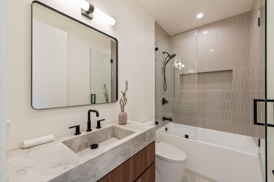 Common bathroom with bathtub and glass-enclosed shower. - 836 Waterloo St