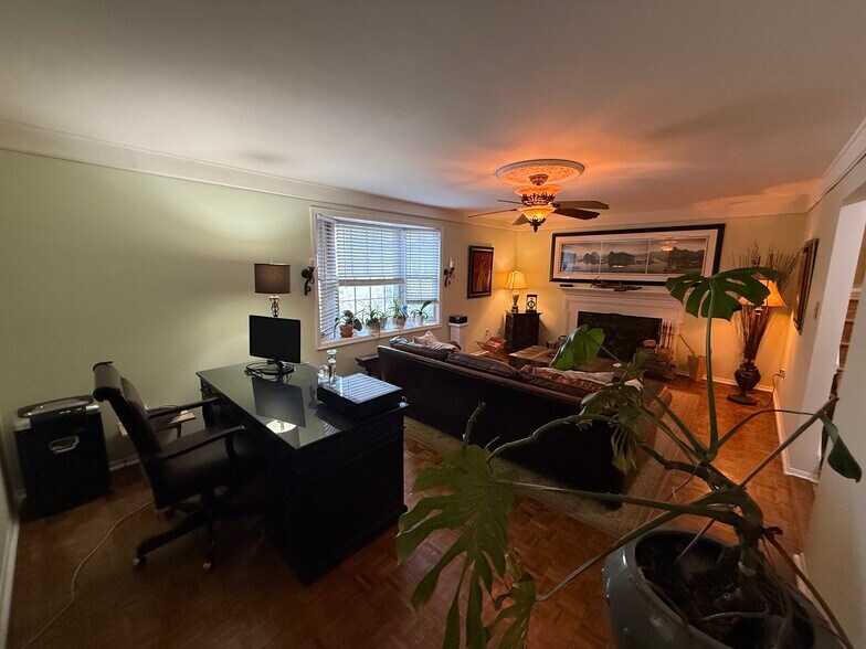 Cozy living room enhanced with a large bay window allowing natural light and a traditional wood burn - 3307 Webley Ct