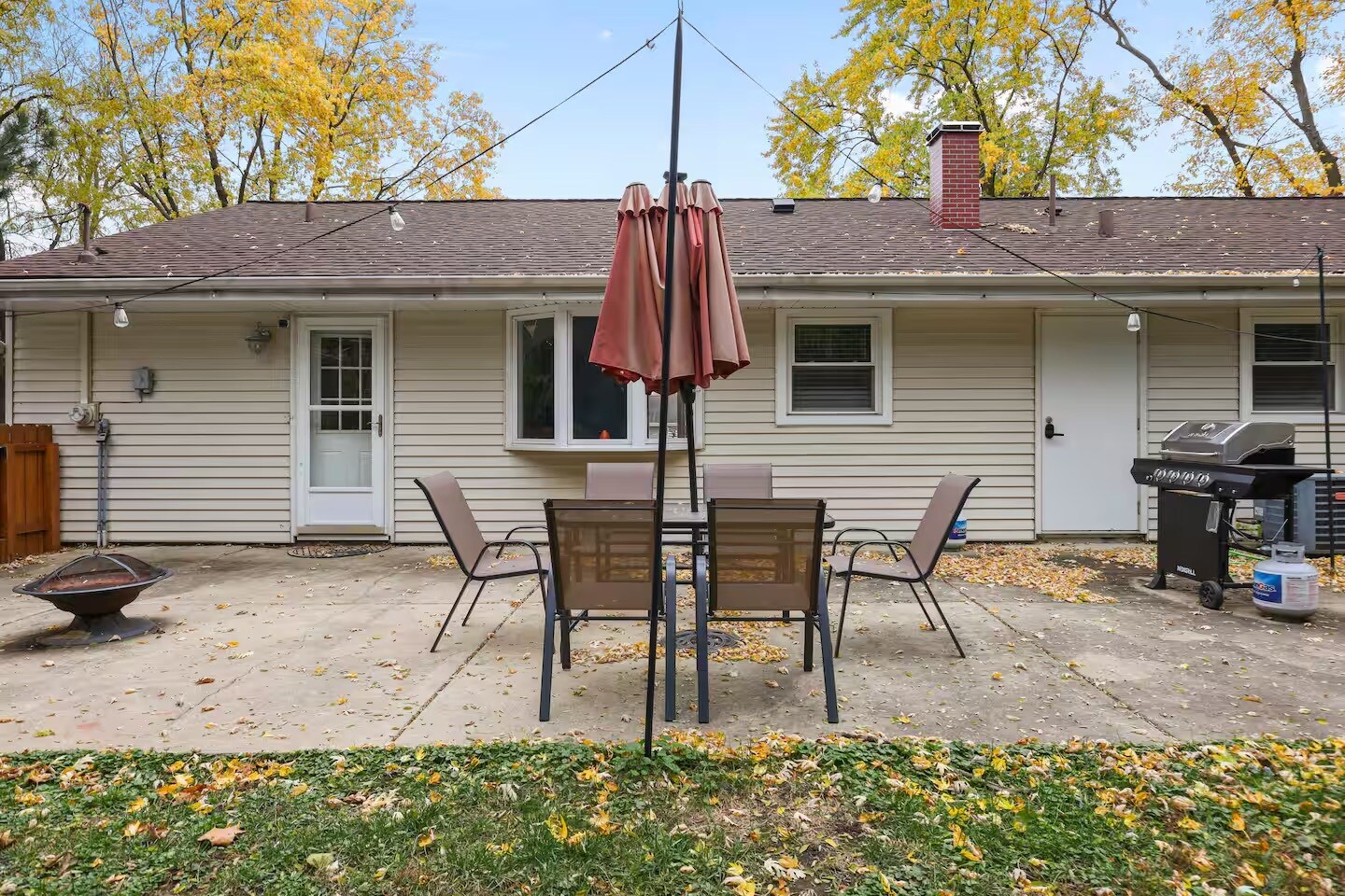 Outdoor patio table set with umbrella, grill and fire pit. Fenced backyard. - 1002 Juniper Ln