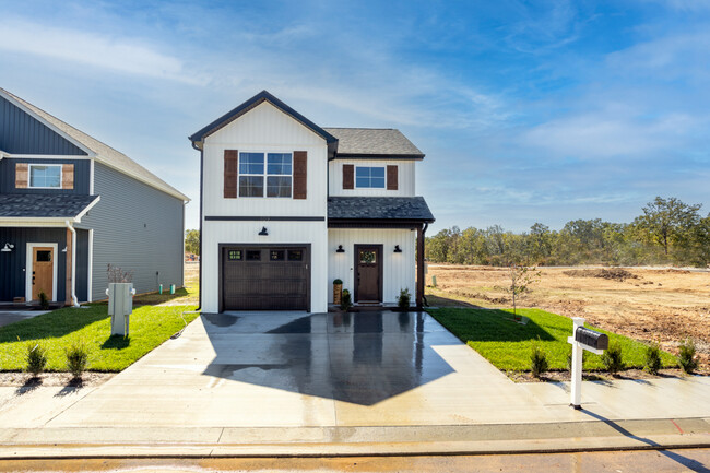 Exterior feat. modern siding, driveway, mailbox, and attached garage. - 110 Sierra Cir