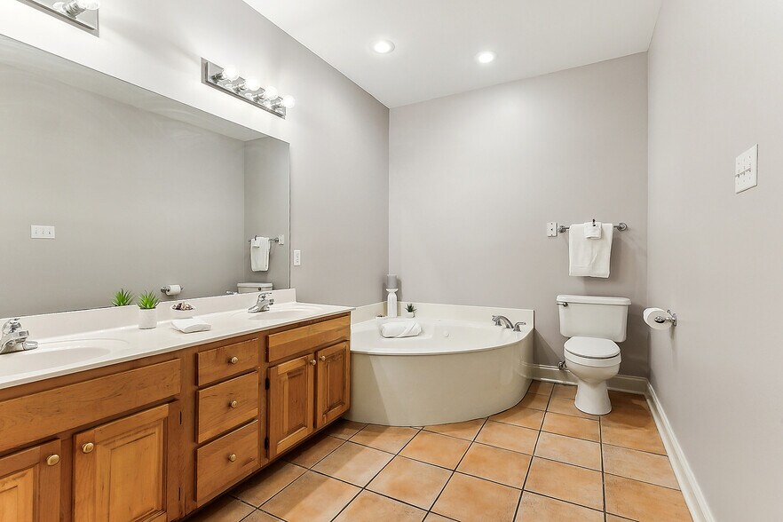 Primary ensuite bathroom features double vanities, jacuzzi tub and separate shower - 3245 Iowa Ave