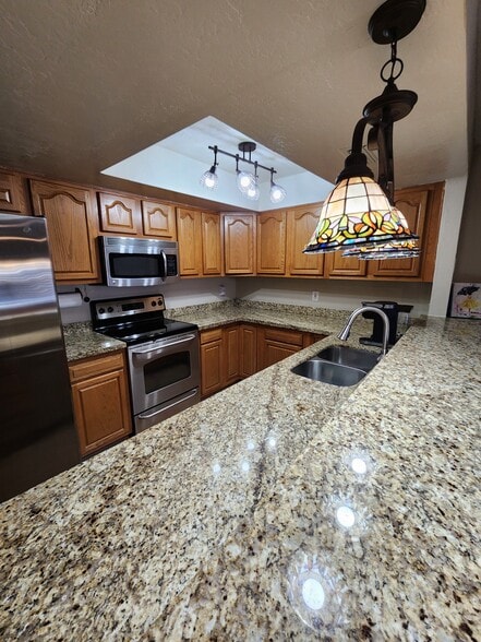 Modern kitchen with deepe 2 side stainless steel sink, granite countertops and bar. - 5050 N 81st St