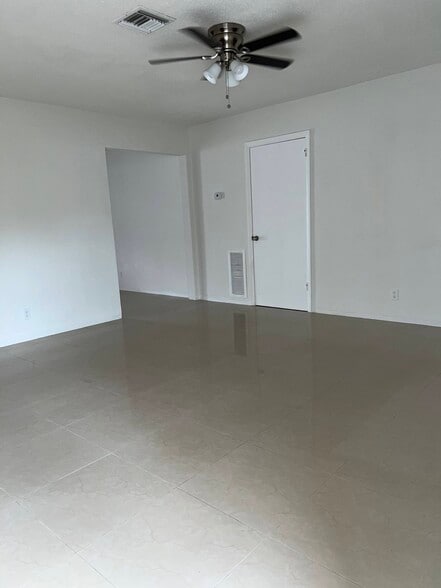 Living room: porcelain floors throughout. Ceiling fan in living room and two bedrooms - 5010 SW 26th Ave