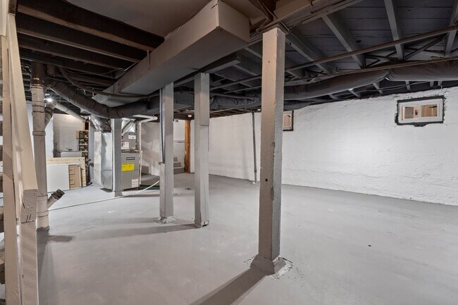 Unfinished, walk out basement with brand new sump pump and excellent lighting offering ample storage - 4517 Tracy Ave