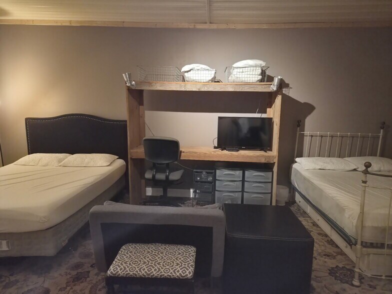 King and queen beds separated by a craft style desk. More storage and small sofa. - 7 Canterbury Ct SE