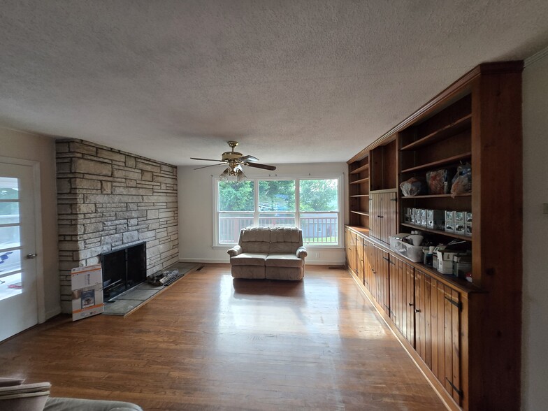 Bookshelf wall, fireplace, and deck view in livingroom - 507 Robinson Dr