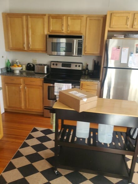 Kitchen with maple cabinetry, granite countertops, and stainless steel appliances. - 1416 Boulevard