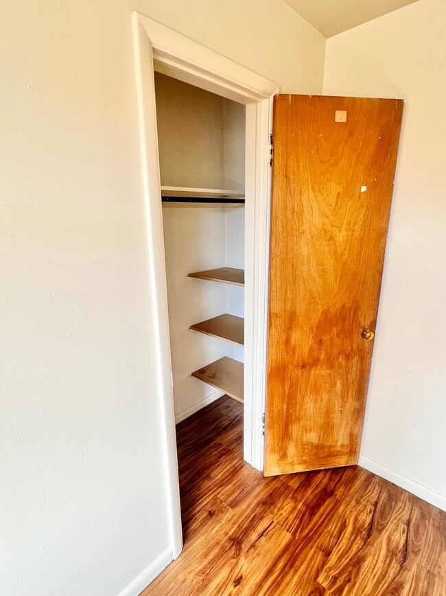 Explore this functional and charming closet space with built-in shelving. - Hillside Apartments