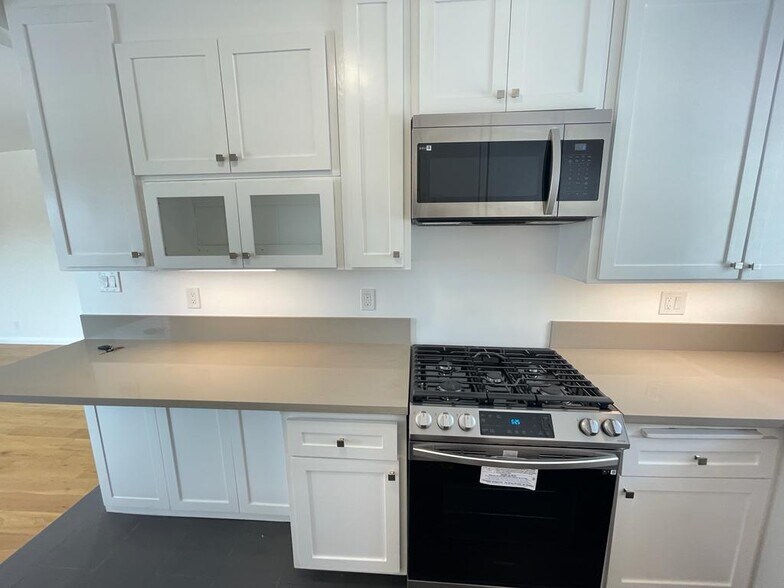 kitchen. samsung gas range and microwave. under counter light - 7855 W Manchester Ave