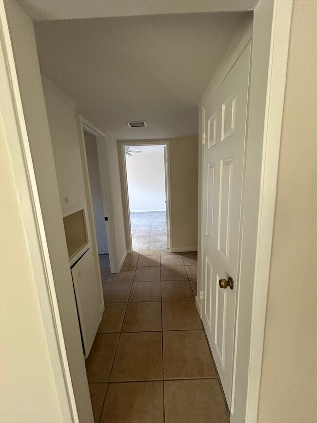 Hallway to master bedroom with closet space on right and storage space on the left - 11690 Kismet Ave