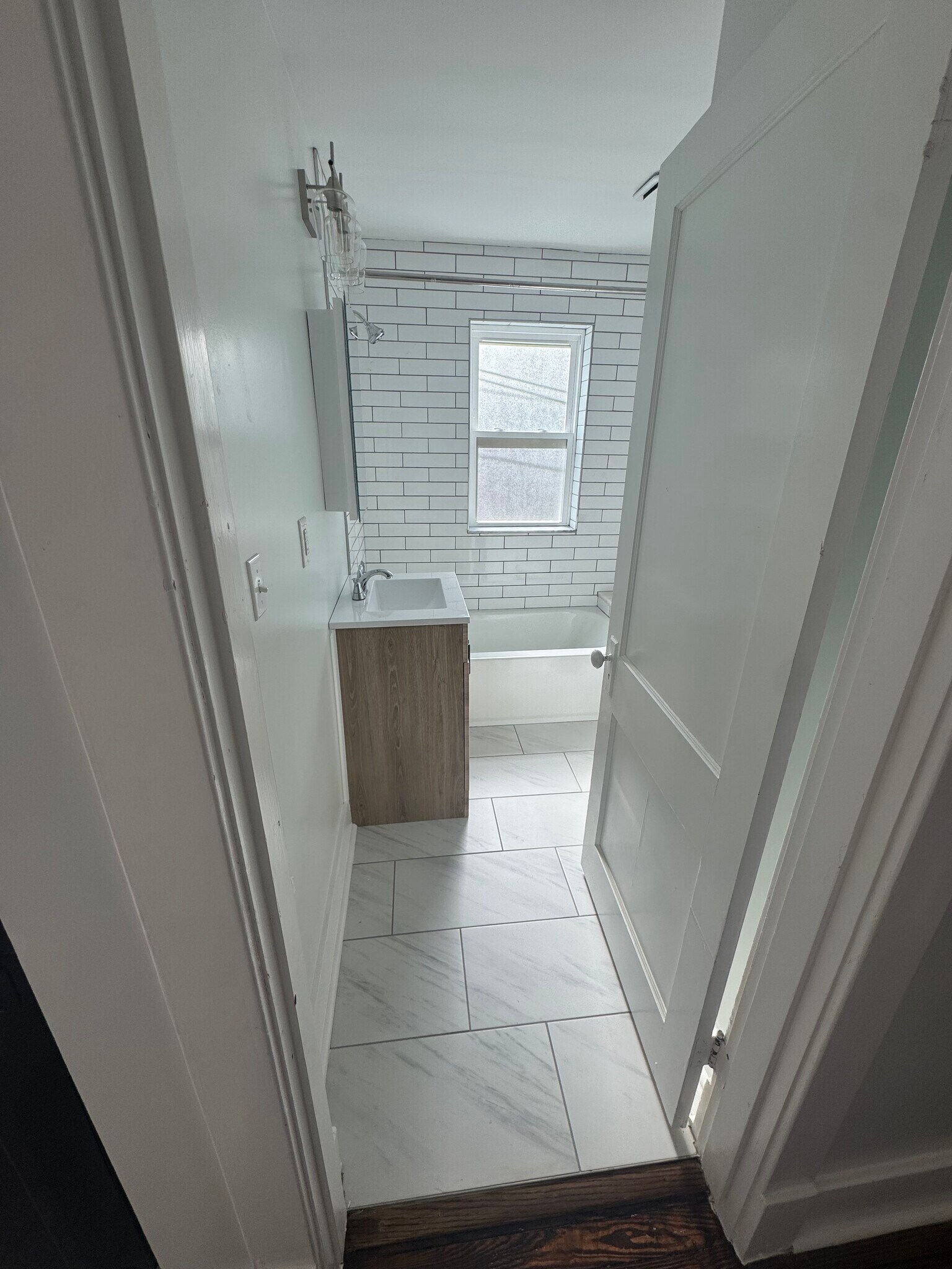 Fully renovated bathroom: new floor tile, tub, toilet, vanity, mirror, and lights - 1333 Castlewood Ave