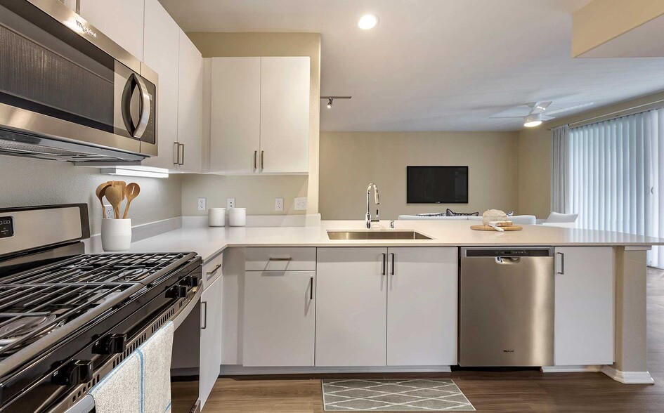 Renovated Package I kitchens with light grey quartz countertops, new white cabinetry, stainless steel appliances, upgraded fixtures, and hard surface flooring throughout - Avalon Camarillo