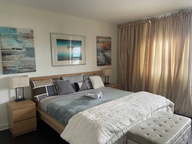 eastern exposure bedroom with king size bed and a working station - 1500 Bay Rd