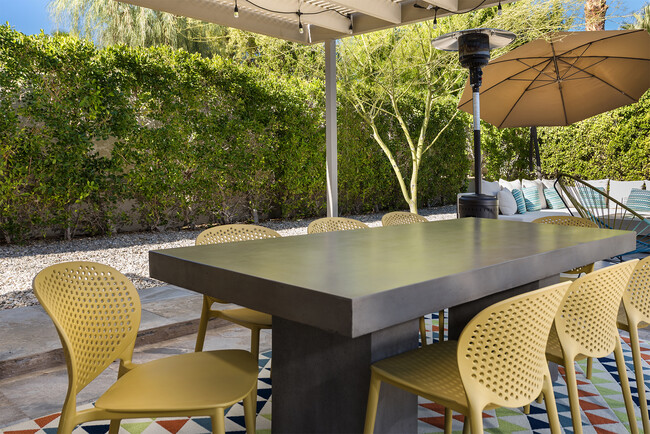 Enjoy outdoor dining for eight with views of the pool, perfect for al fresco meals and gatherings. - 71535 Biskra Rd