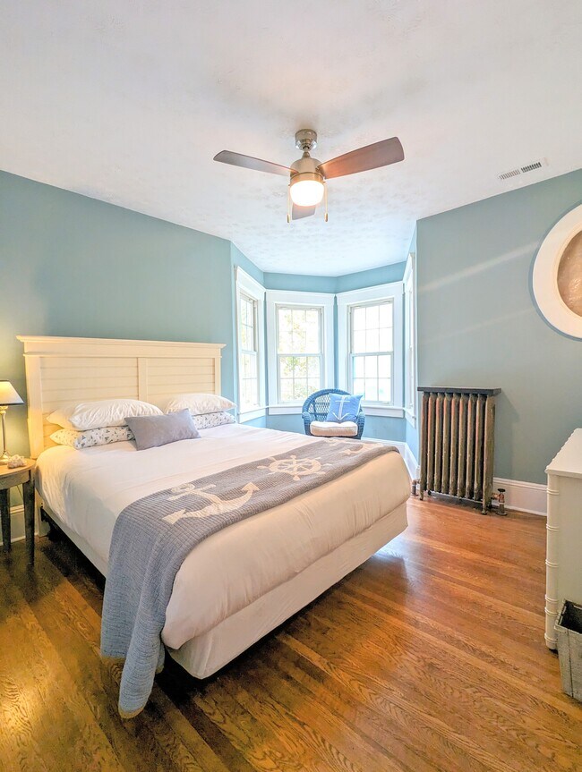 Primary bedroom with queen bed, dresser, light-filled sitting area - 7216 W Clinton Ave