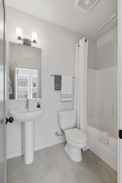 Perfect for guests or first-floor living, complete with tub/shower combo and sleek pedestal sink. - 358 E Village Ln
