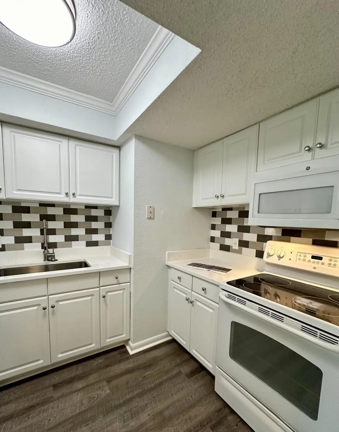 Bright white kitchen with classic quartz counters - 100 Fairway Park Blvd