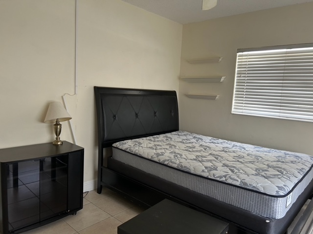 queen bed and desk in bedroom - 480 NW 20th St