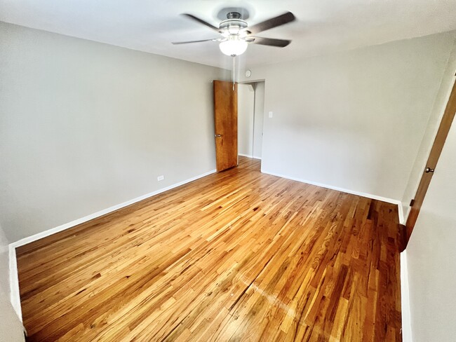 Step into comfort with this inviting room featuring elegant hardwood flooring. - The Birney Apartments