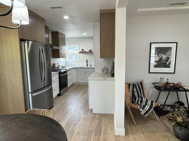 Kitchen with brand new stainless steel appliances to the left and living room to the right - 5950 Simpson Ave