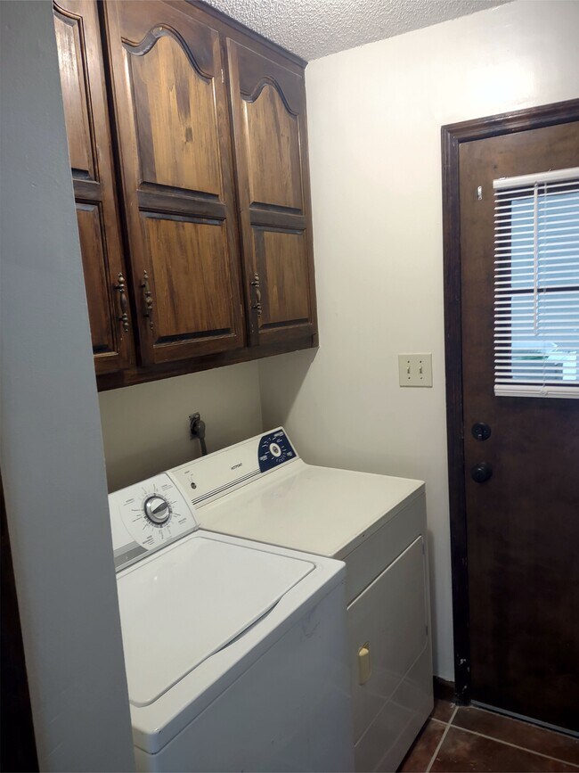 Utility room w/Washer-Dryer (*not included) hook-up, cabinets, closet & access to enclosed garage. - 120 Arrow Lands Trl
