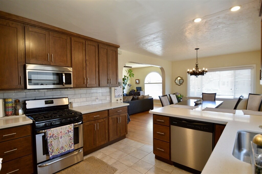 Newly remodeled Kitchen with 4 year old dishwasher, microwave, stove, fridge and large under mount sink. White Quartz counter tops, white and light grey marble back splash, and alder cabinets. - 4770 Bancroft St