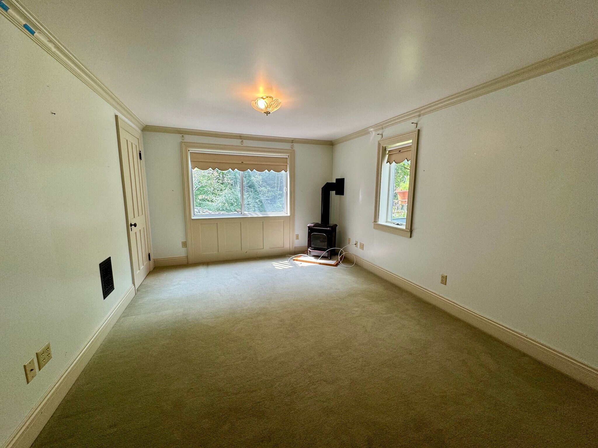 Lower level family room with wood stove, door to laundry room - 113 Penny Ln