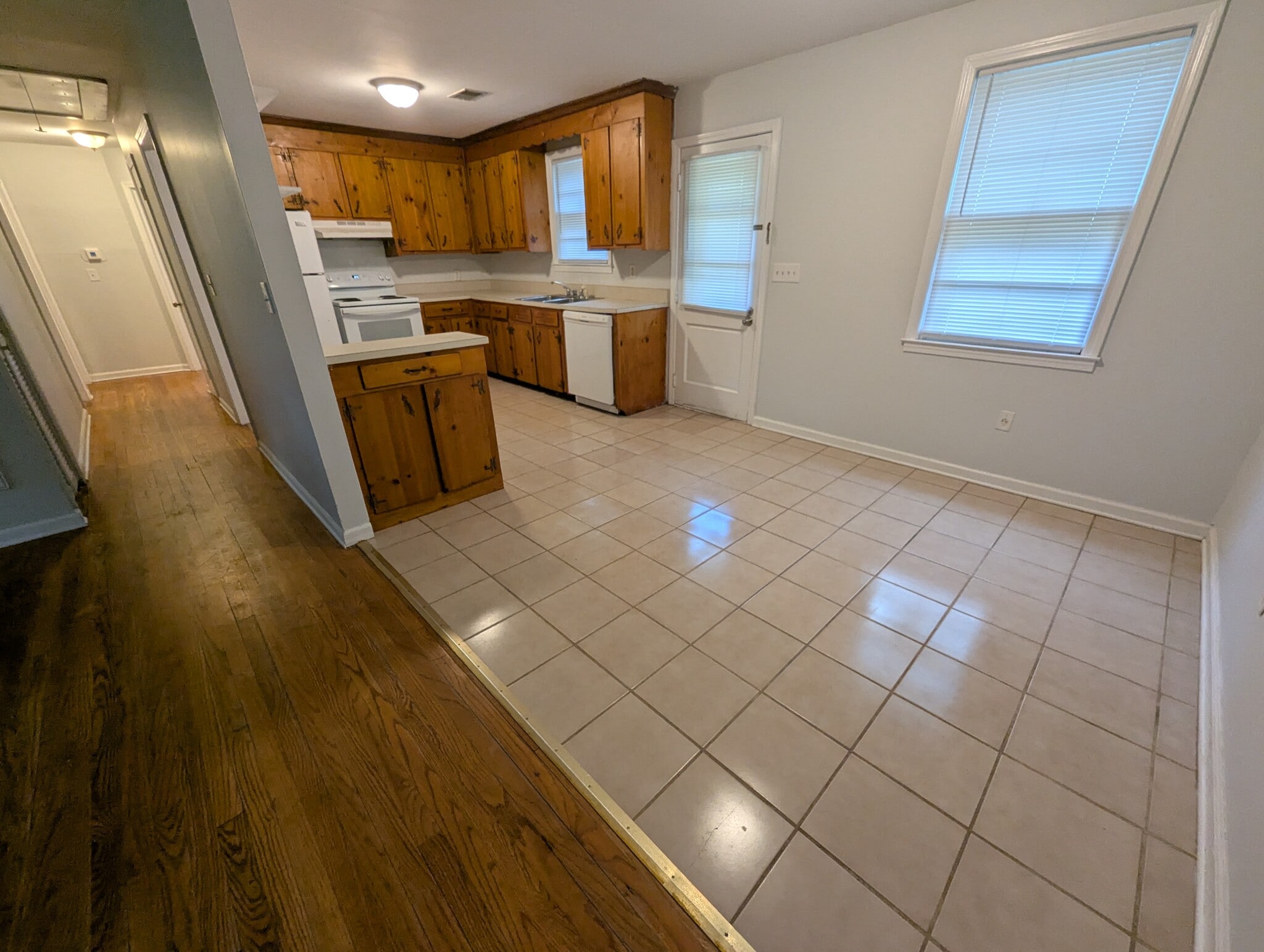Bright, open kitchen layout showcasing extensive counter and cabinet space with dual windows. - 1527 Brookbank Ave