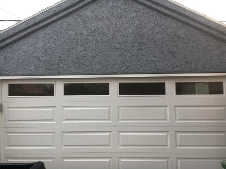 Two-car garage with sliding doors leading to private back patio. - 806 E 65th St