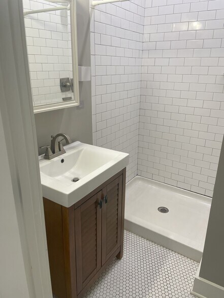 Bathroom with vanity, tiled shower, and medicine cabinet for storage - 460 E Pharr Rd