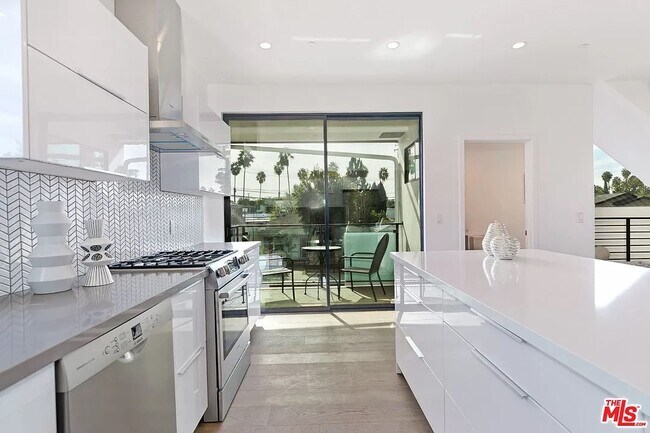 Large, South-facing sliding door provides access to kitchen balcony - 6077 Hargis St