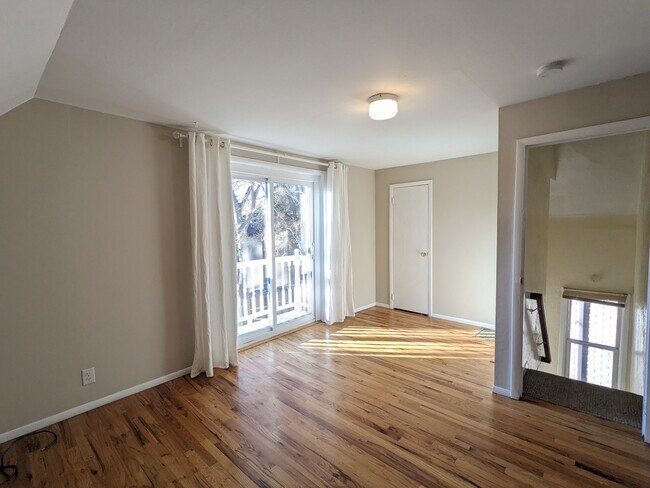 Living room, with stairs to front door on the right. - 628 S Washington St