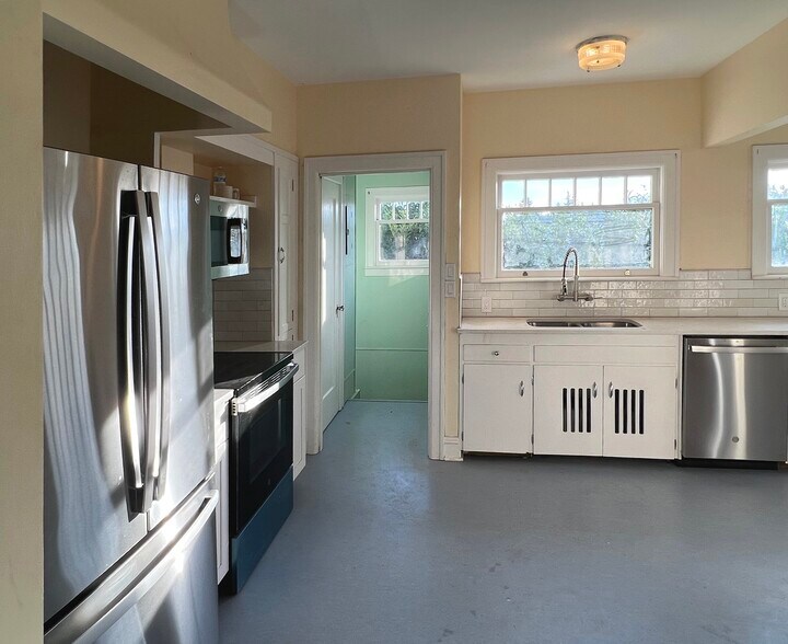 Main floor kitchen showing hallway to the pool patio and downstairs living space - 3448 SW Canby St