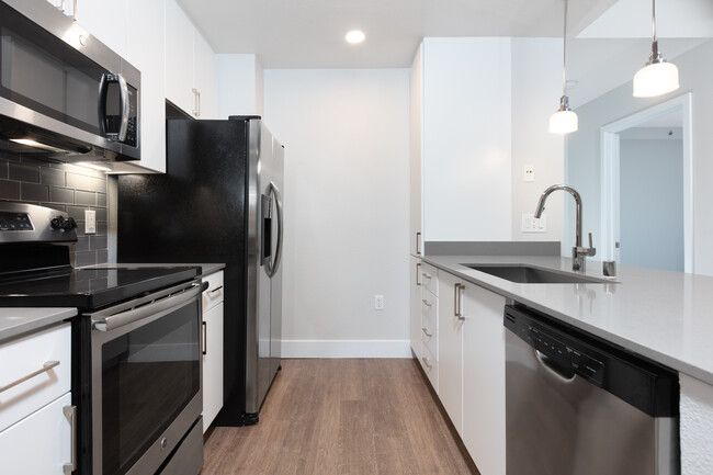 Renovated Phase I kitchen with stainless steel appliances and hard surface flooring - Avalon at Mission Bay