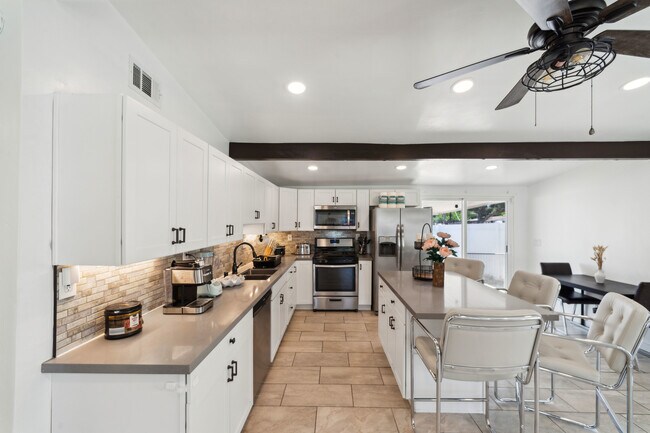 Sit at the kitchen island or grab a drink while keeping the chef company. - 9853 Saint George St