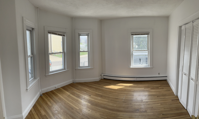 Front bedroom (1st) with plenty of natural light and a spacious walk-in closet. Queen/full. - 58 S Waverly St