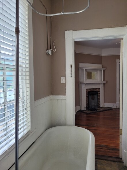 Bathroom - Original clawfoot bathtub & slate tile floor. View of fireplace in dining room - 1215 Java Pl