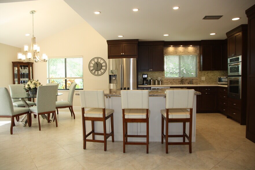 Remodeled kitchen with stainless steel appliances, granite island and quartzite countertops, custom cabinetry with soft closures and full walk-in pantry. - 2662 NW 42nd St