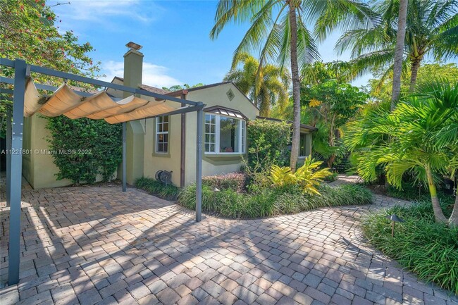 Tropical vegetation & tall palm trees grace this paver walkway while an adjustable canvas awning pro - 1109 NE 3rd St