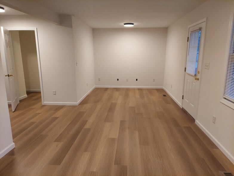 Large living room with view of front door and door to laundry and half bath - 340 W German St