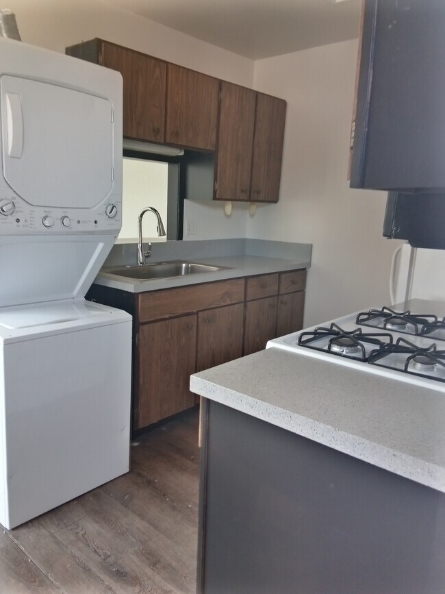 Kitchen with gas stove and washer dryer combo - 10762 E Exposition Ave