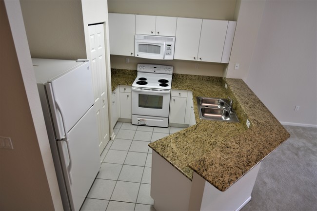 Kitchen with granite countertop - 5036 SE Mariner Garden Cir