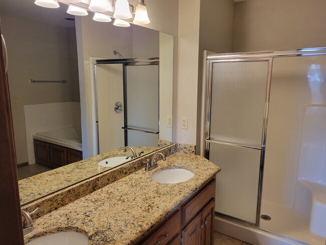 Master bath with double vanities in granite. - 921 Blue Ridge Dr