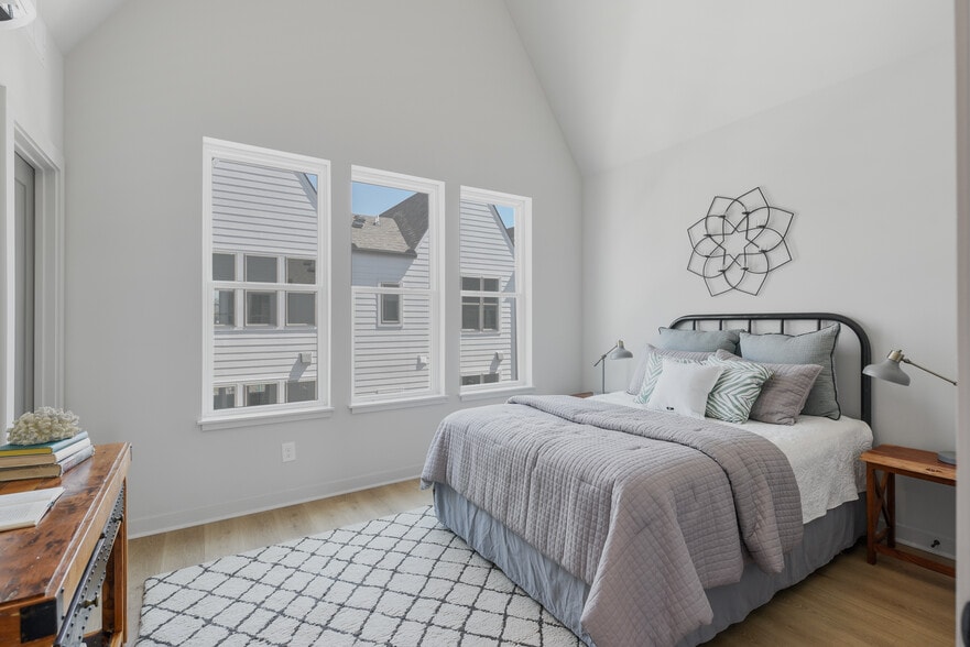 Vaulted ceilings and triple windows make this secondary bedroom feel open, bright, and serene. - 358 E Village Ln