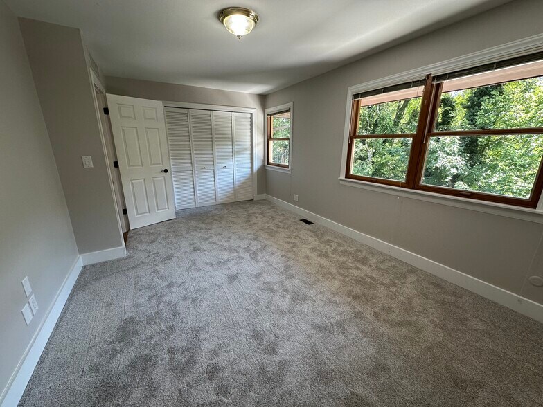 Master bedroom with large windows viewing nature. - 2154 Willowgrove Ave