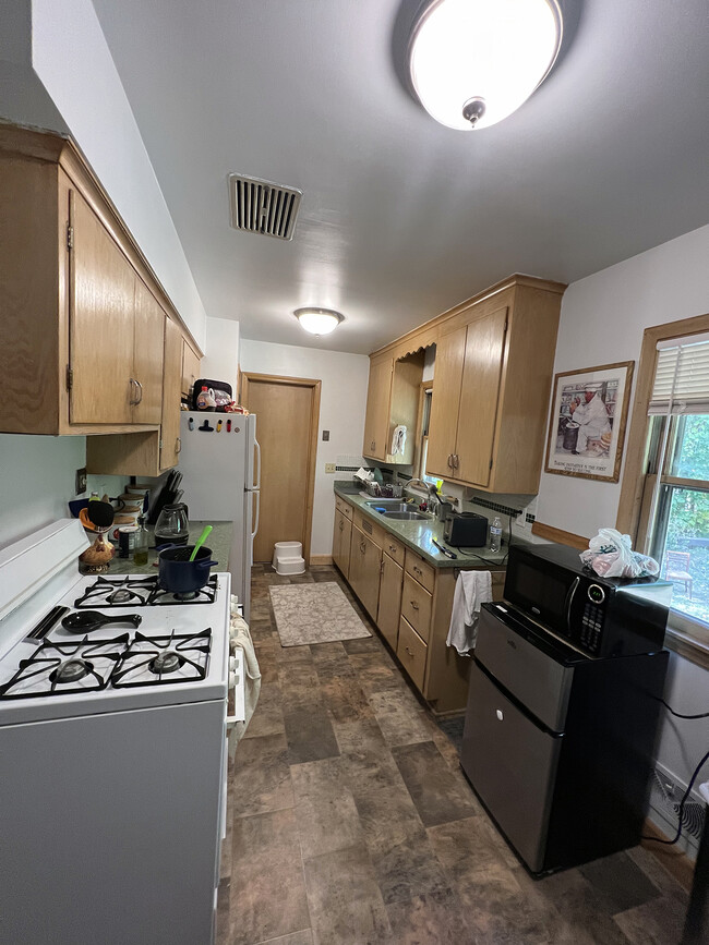 Kitchen with pantry and vent fan over stove. - 1911 Talmage Ave SE