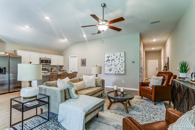 a living room with furniture and a ceiling fan - Cottages at Parkstone