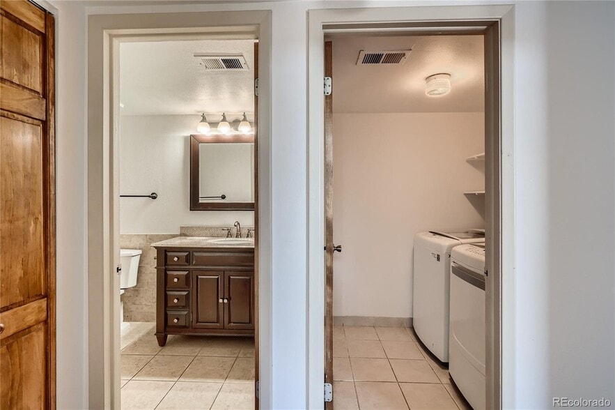 Hallway with entrance to bathroom (left) and laundry room (right) - 14282 E Tufts Pl